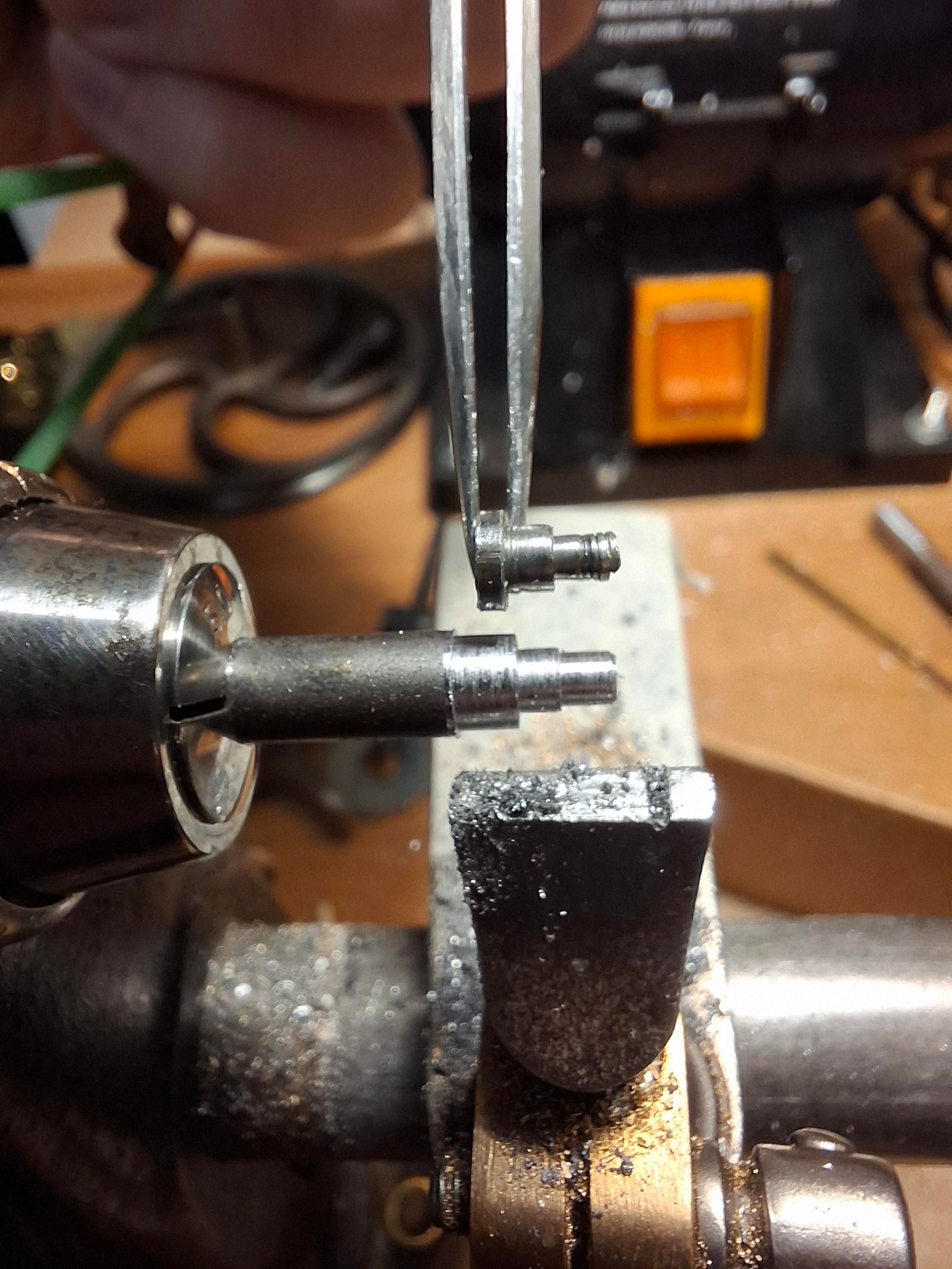 Barre d'acier que je forme au burin pour ressembler à la vis originelle que je tiens à la brucelle