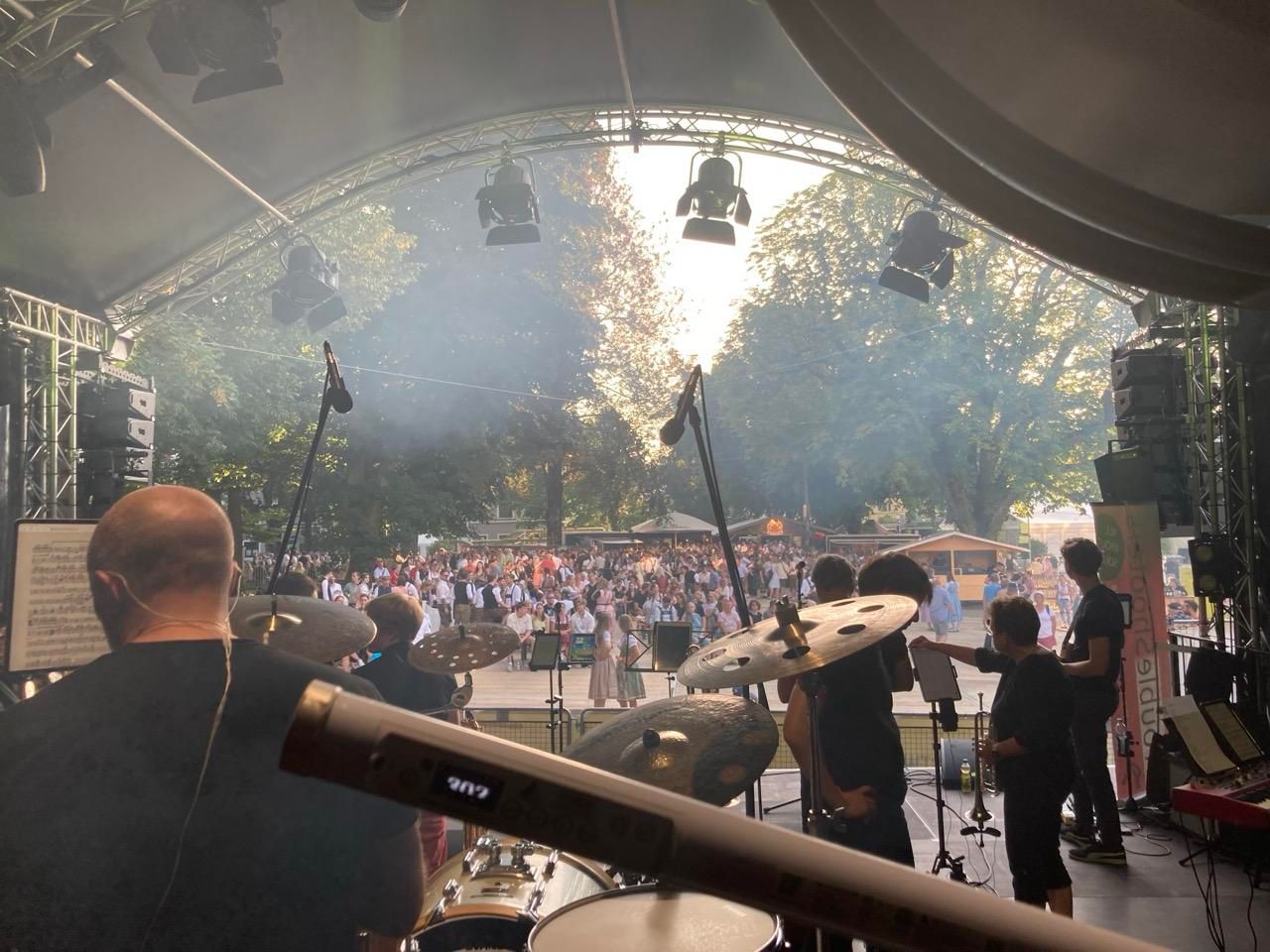 Blick von der großen Bühne ueber einen großen Platz, mit der Sonne im Hintergrund