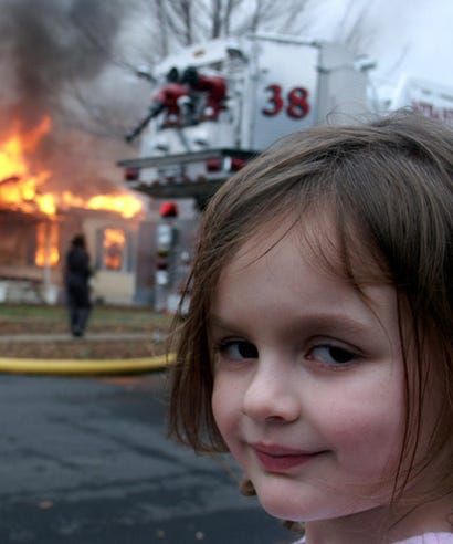 Disaster girl watching a house burning with a smirky smile