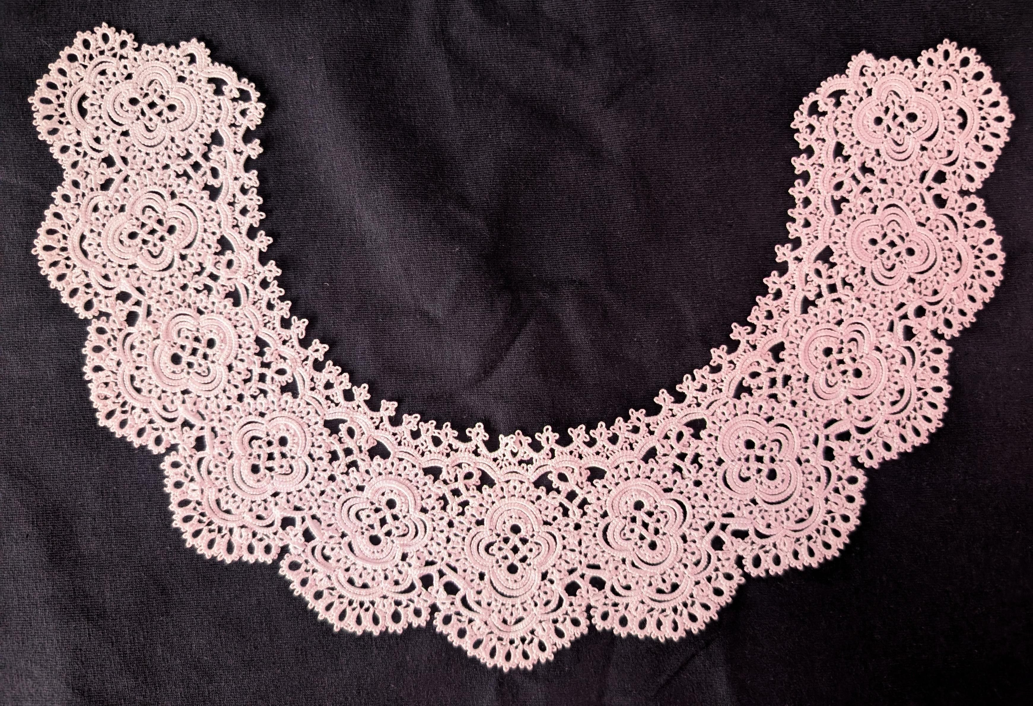 A top down photo of a extremely intricate lace collar. The design is composed of 11 medallions that connect together in a semicircle.
