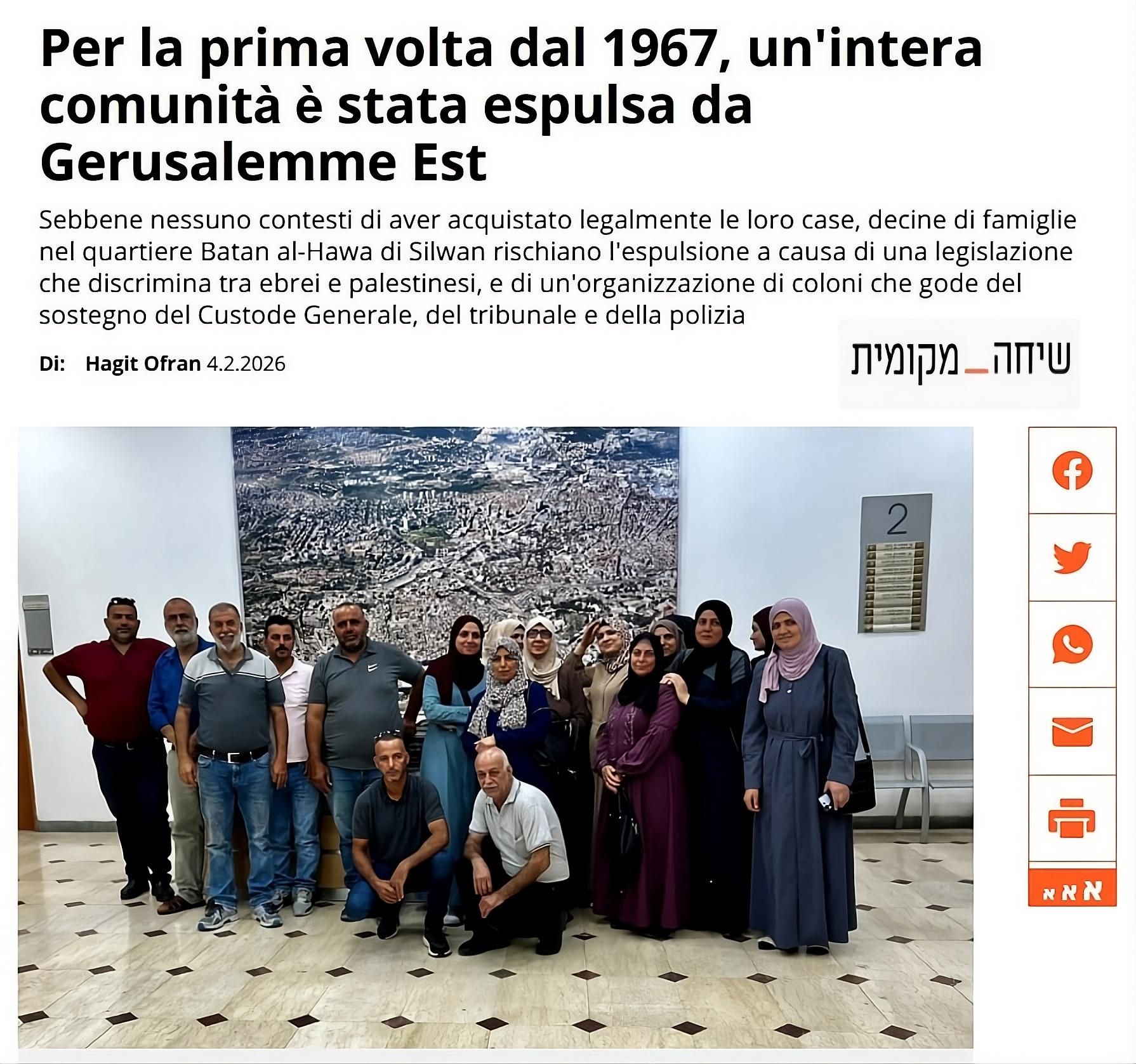 Screenshot di un articolo che riporta la frase: “Per la prima volta dal 1967, un’intera comunità è stata espulsa da Gerusalemme Est”. L’immagine mostra un gruppo di persone in piedi in un corridoio interno, davanti a una grande fotografia aerea della città di Gerusalemme appesa alla parete. Tra loro ci sono uomini e donne, alcuni in abiti tradizionali, altri in abbigliamento moderno. L’ambiente ricorda un edificio pubblico, con sedute laterali e segnaletica murale. Il testo visibile spiega che decine di famiglie del quartiere Batan al-Hawa, a Silwan, rischiano l’espulsione nonostante abbiano acquistato legalmente le loro case, a causa di una legislazione che distingue tra ebrei e palestinesi e del sostegno istituzionale a un’organizzazione di coloni. La didascalia contestualizza un episodio di sgombero forzato e le sue implicazioni politiche e legali.