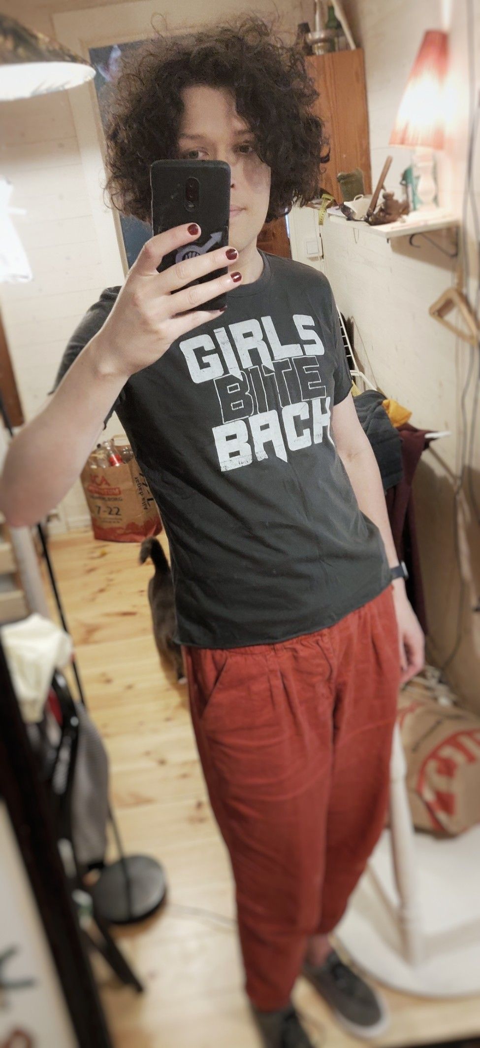 Full body selfie. I'm wearing red pants and a black t-shirt that says “girls bite back”