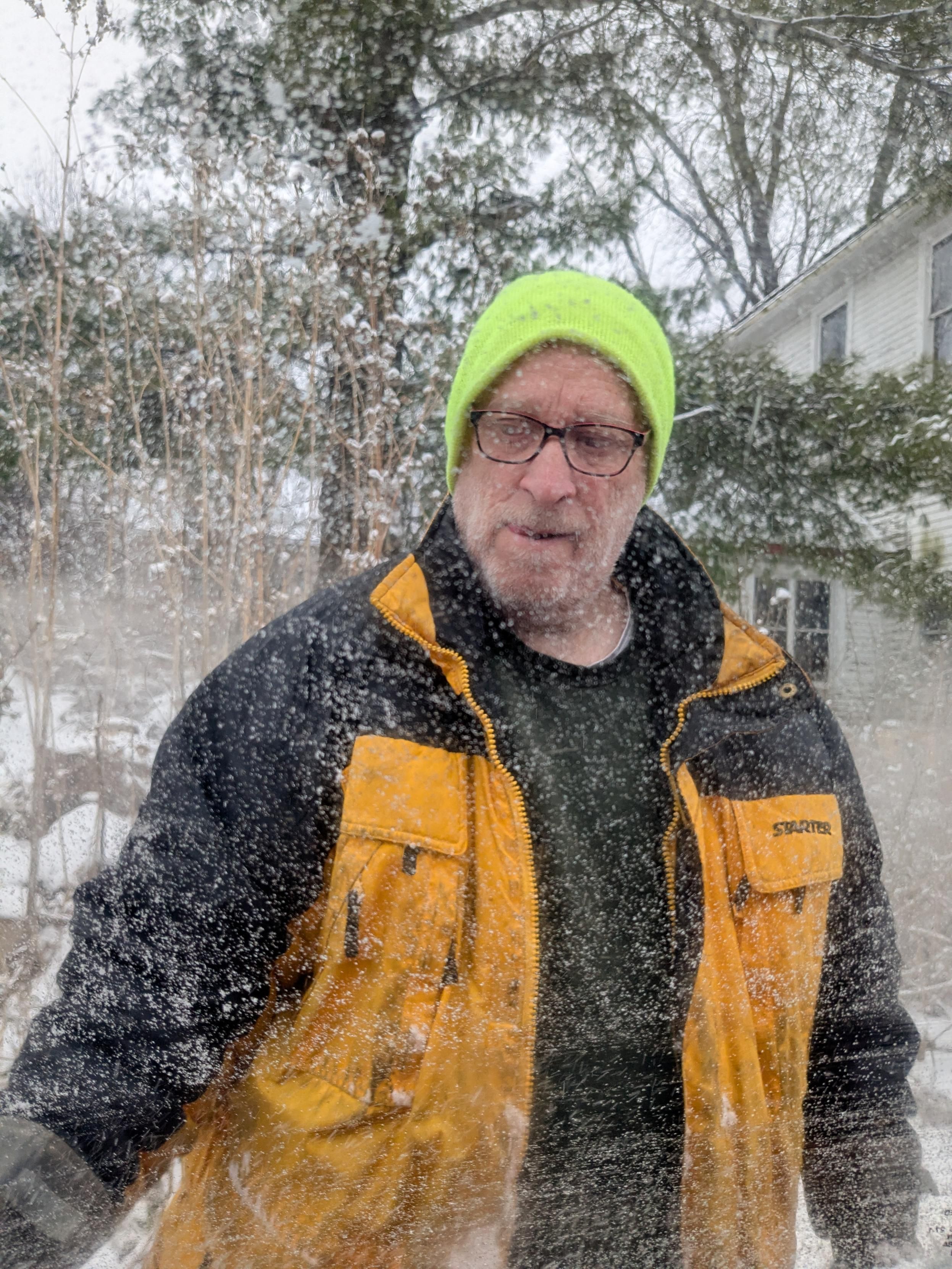 A man in a yellow jacket in the snow 